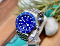 Tudor Pelagos 42 blue dial and titanium bracelet, styled lifestyle shot on wood surface with greenery