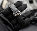 Omega Speedmaster Professional Moonwatch stainless steel buckle engraved with the Omega logo on black leather strap, close-up