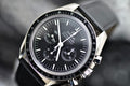 Omega Speedmaster Professional Moonwatch Co-Axial Master Chronometer black chronograph dial and black tachymeter bezel, close-up angled view